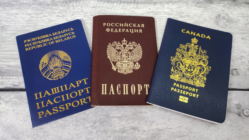 Паспорта Беларуси, России и Канады на деревянной поверхности