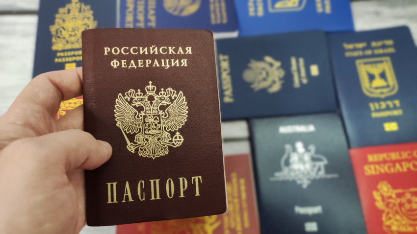 Паспорт России в руке на фоне паспортов разных стран