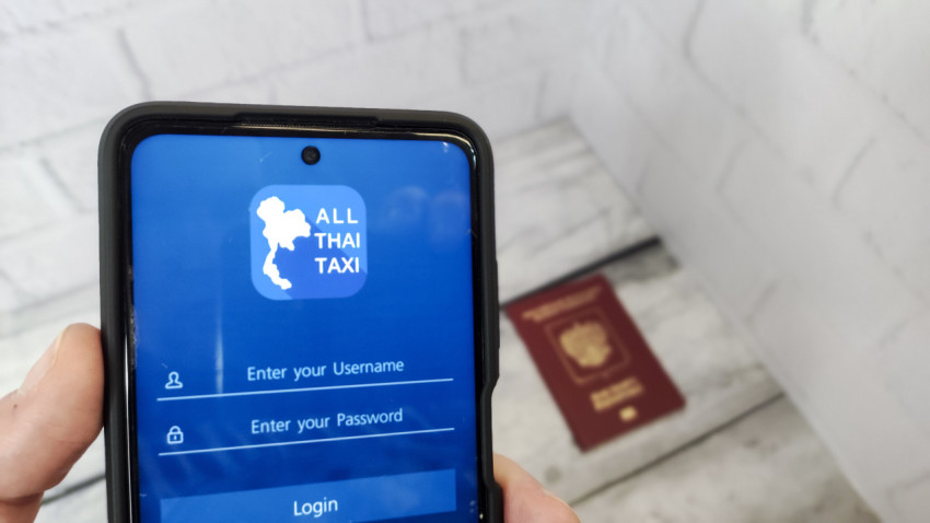 Приложение All Thai Taxi на экране смартфона с загранпаспортом на заднем плане
