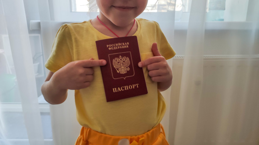 Девочка показывает загранпаспорт РФ