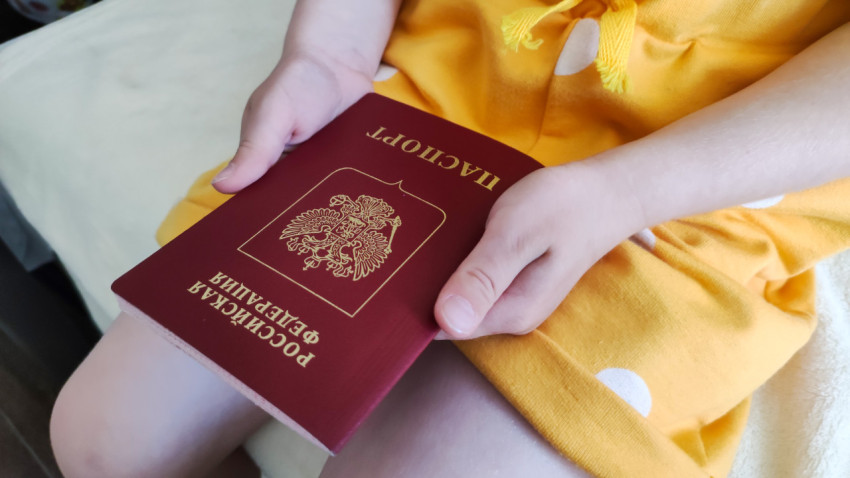 Ребенок держит загранпаспорт РФ в руках