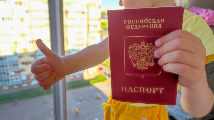 Ребенок с загранпаспортом РФ и жестом «палец вверх»