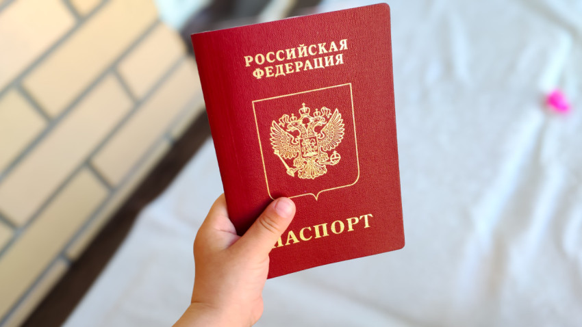Детская рука держит загранпаспорт РФ