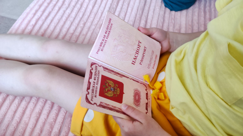 Ребенок держит раскрытый загранпаспорт РФ