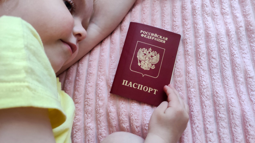 Ребёнок лежит рядом с загранпаспортом Российской Федерации
