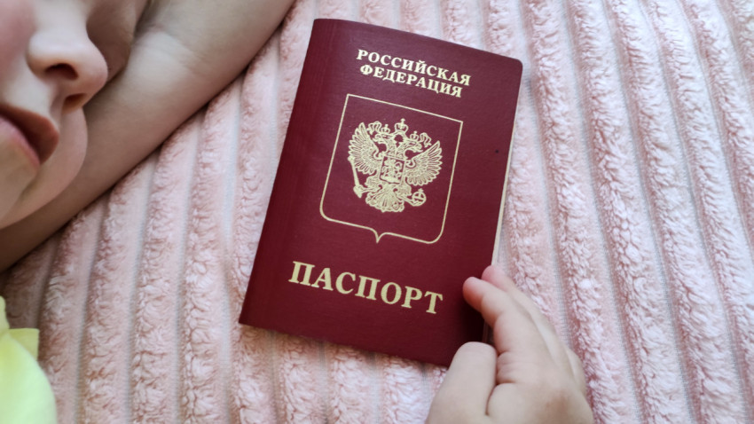 Ребёнок держит заграничный паспорт в домашней обстановке