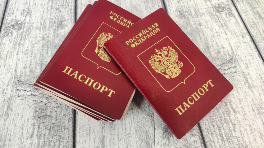 Несколько загранпаспортов России на деревянной поверхности