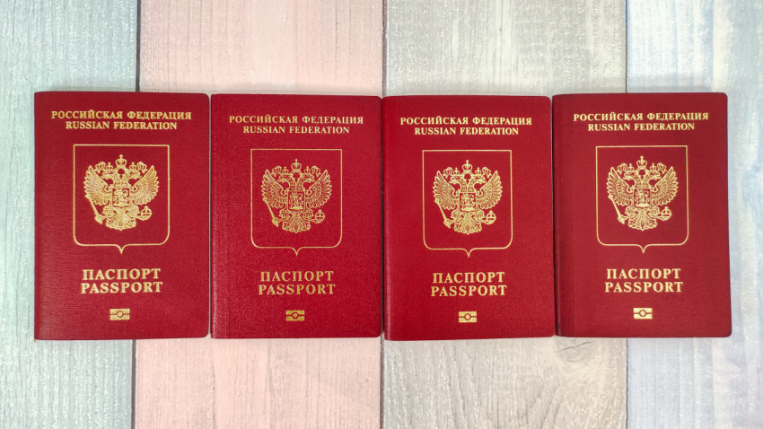 Четыре загранпаспорта Российской Федерации на деревянном фоне