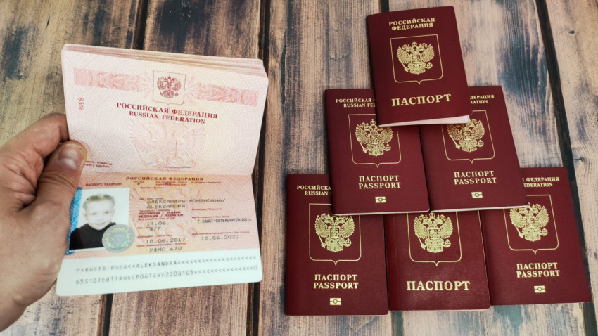 Загранпаспорт старого образца с фотографией ребёнка в руке