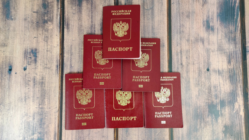Загранпаспорта России разных образцов на деревянной поверхности