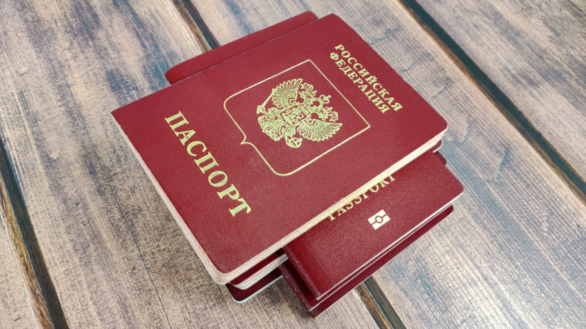 Стопка загранпаспортов России разных образцов на деревянном столе