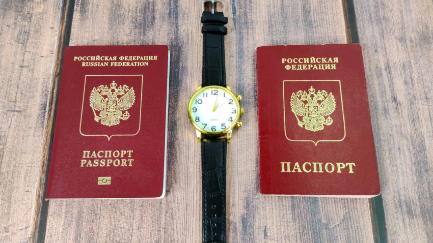 Российские заграничные паспорта и наручные часы на столе