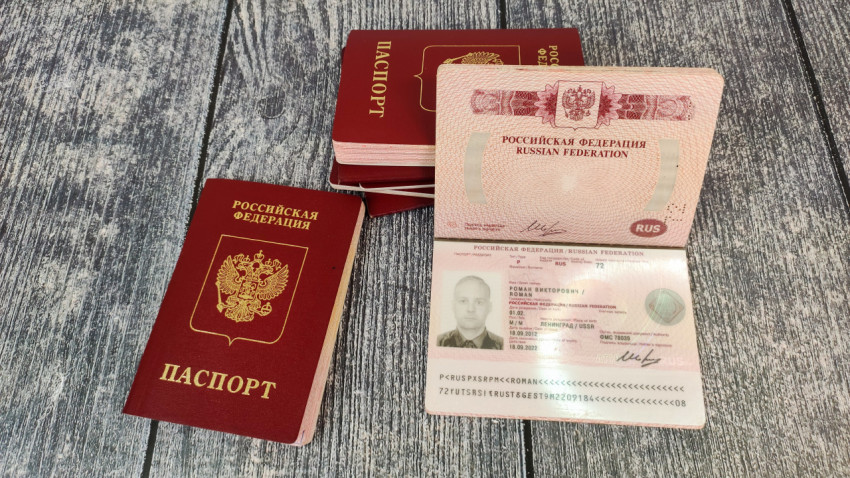 Загранпаспорт Российской Федерации с раскрытой страницей и стопкой документов