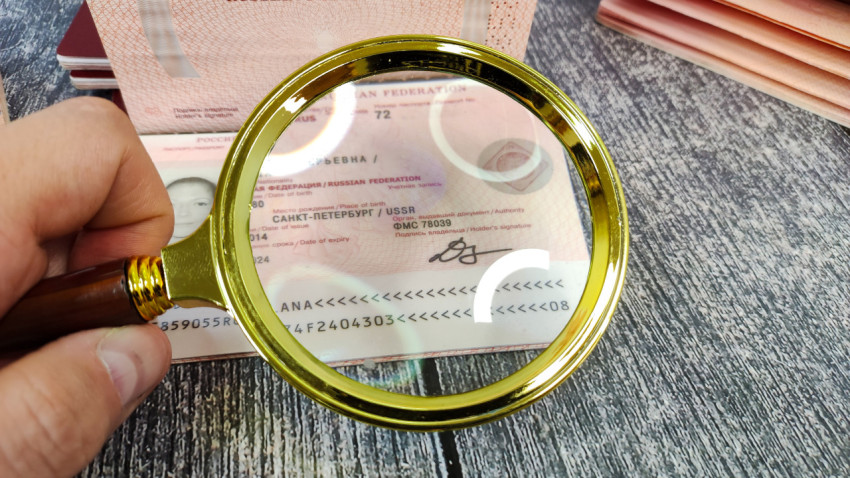Проверка заграничного паспорта Российской Федерации под увеличительным стеклом
