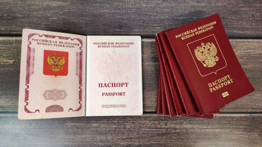 Заграничный паспорт РФ раскрытый рядом с другими документами