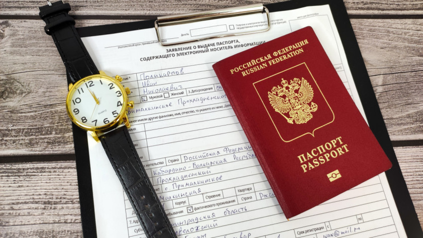 Загранпаспорт и заполненное заявление на фоне наручных часов