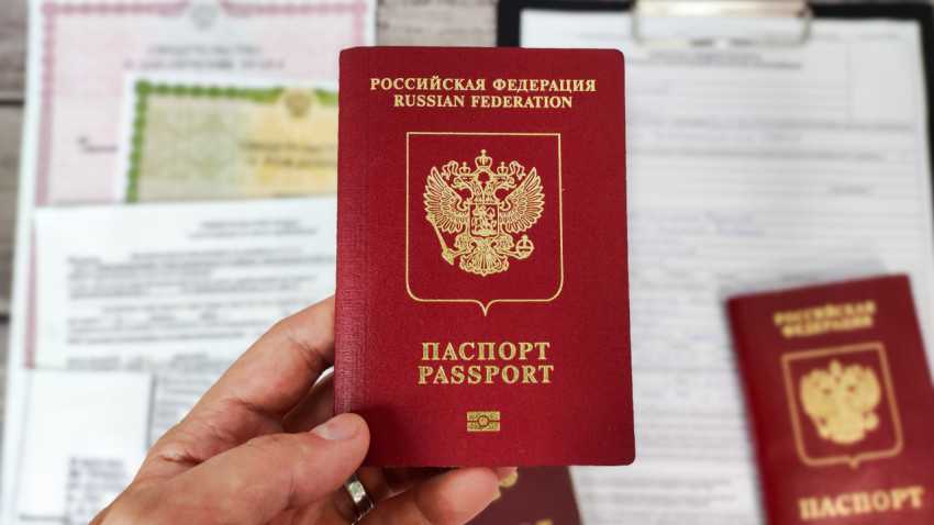 Загранпаспорт РФ в руке на фоне документов