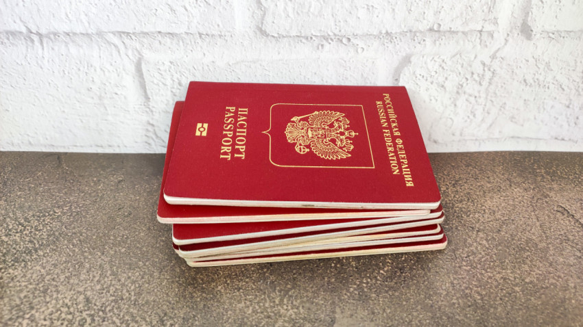 Стопка загранпаспортов РФ на столе у стены