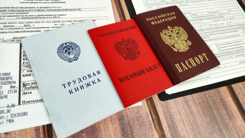 Трудовая книжка, военный билет и внутренний паспорт Российской Федерации на фоне документов