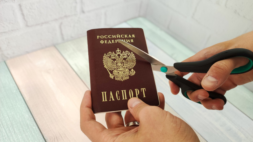 Ножницы разрезают паспорт Российской Федерации
