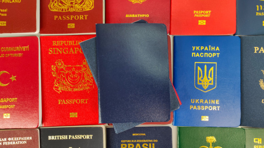 Паспорта разных стран мира на фоне с пустой синей обложкой