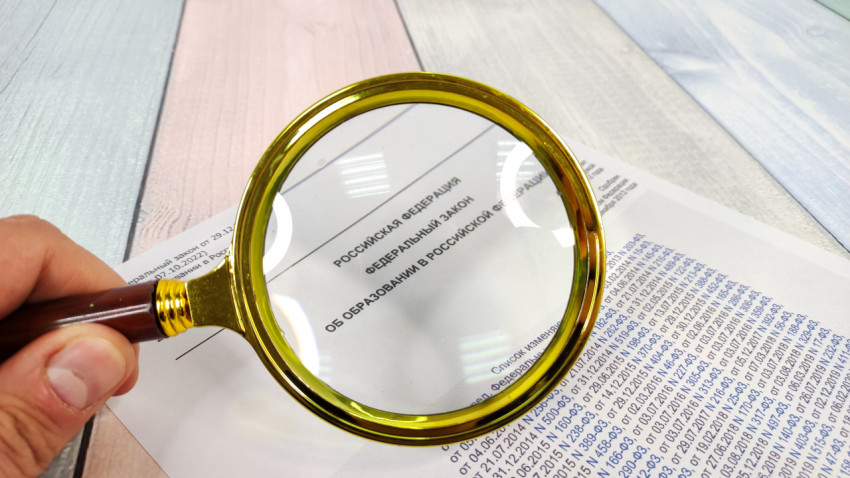 Лупа над текстом федерального закона об образовании