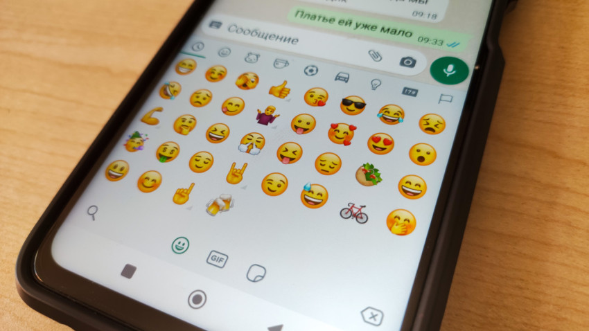 Смартфон с открытым окном мессенджера и эмодзи