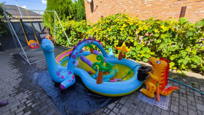 Надувной детский бассейн с игрушками во дворе