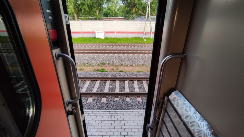 Вид из открытой двери поезда на железнодорожные пути