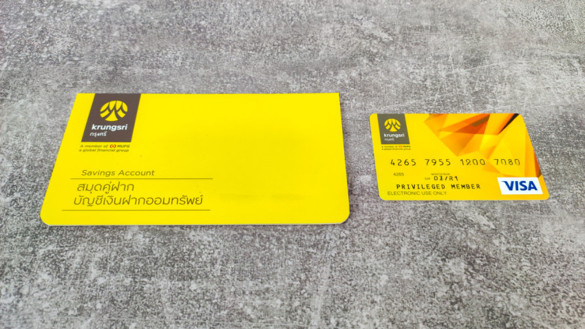 Банковская карта и книжка Krungsri на сером фоне