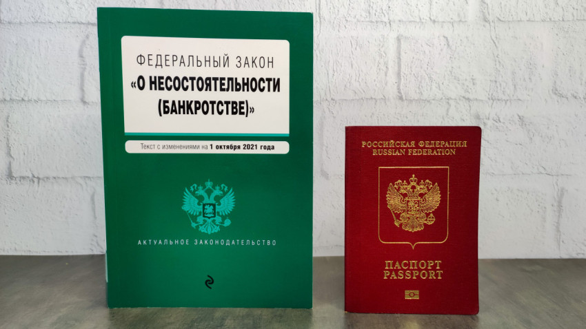 Книга о банкротстве и заграничный паспорт РФ на столе