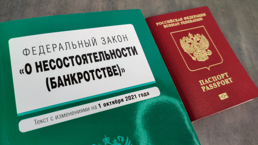 Крупный план книги о банкротстве и заграничного паспорта РФ