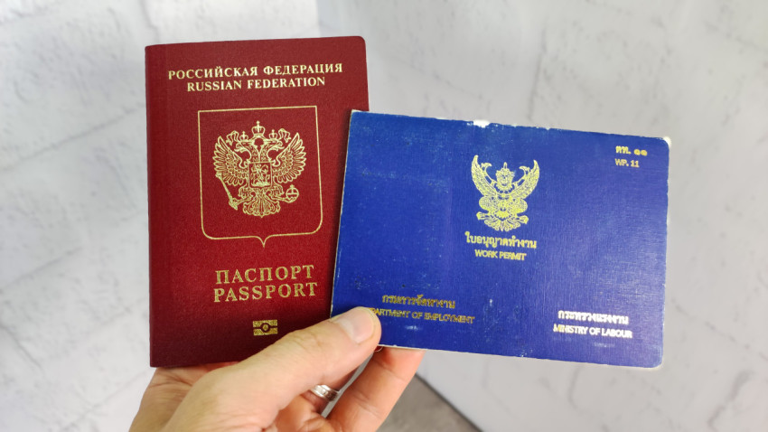 Заграничный паспорт Российской Федерации и рабочее разрешение Таиланда в руке