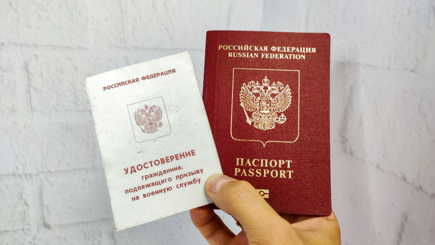 Удостоверение призывника и загранпаспорт РФ в руке