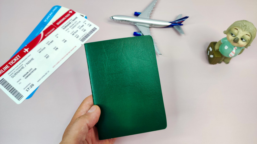 Зеленый паспорт с посадочными талонами и моделью самолета