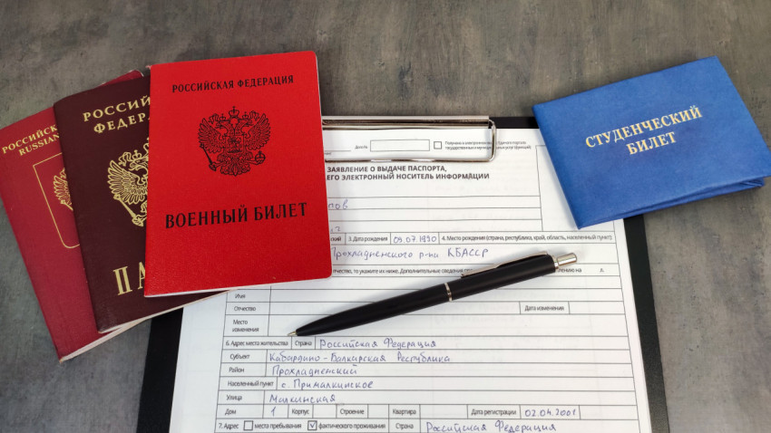 Военный билет, студенческий билет и паспорта на столе с заявлением