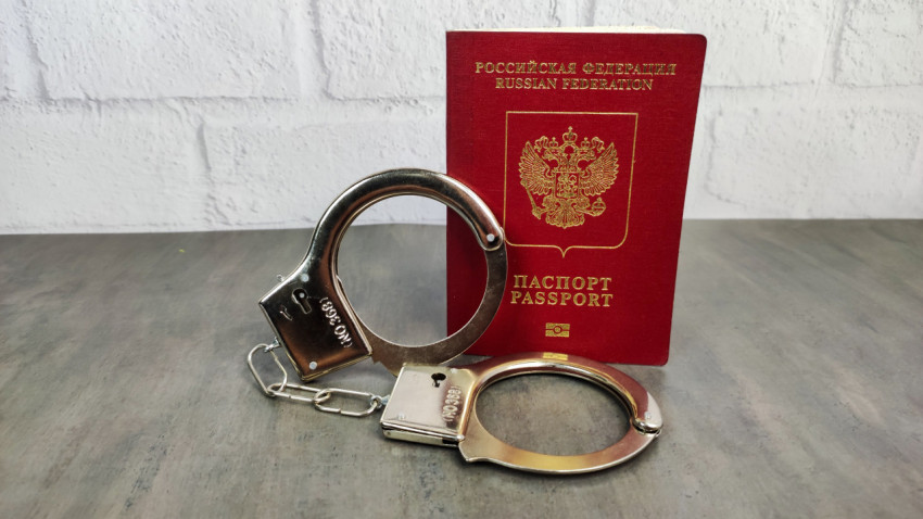 Заграничный паспорт РФ и наручники на столе
