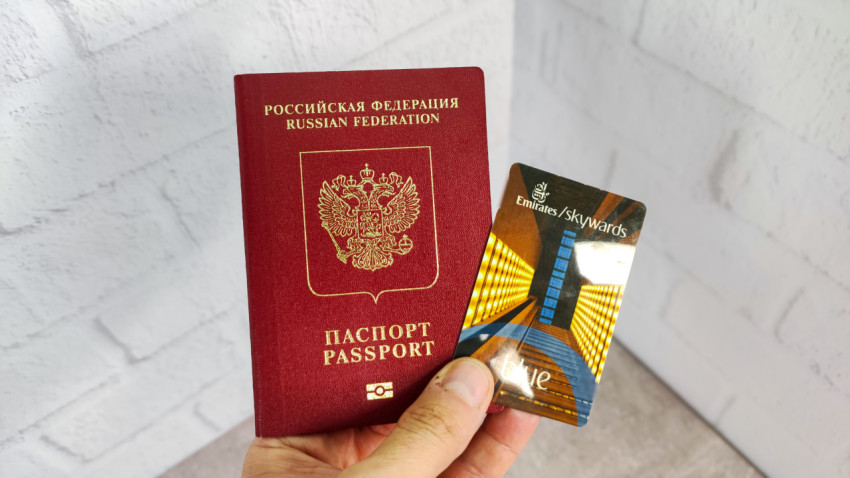 Российский загранпаспорт и карта Emirates Skywards Blue в руке
