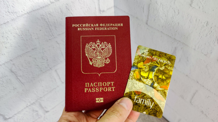 Российский загранпаспорт и карта Emirates Skywards Family в руке