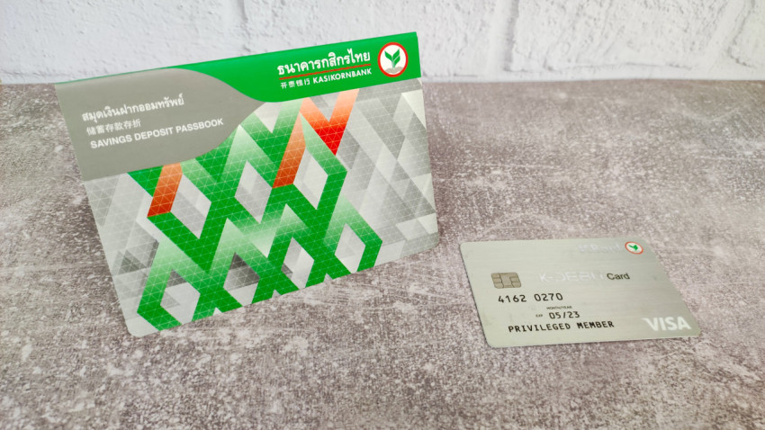 Сберегательная книжка и карта Kasikornbank Visa на сером фоне