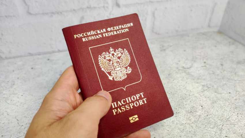 Загранпаспорт РФ в руке на светлом фоне