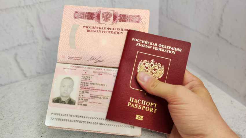 Загранпаспорт в руке с раскрытой страницей с данными владельца