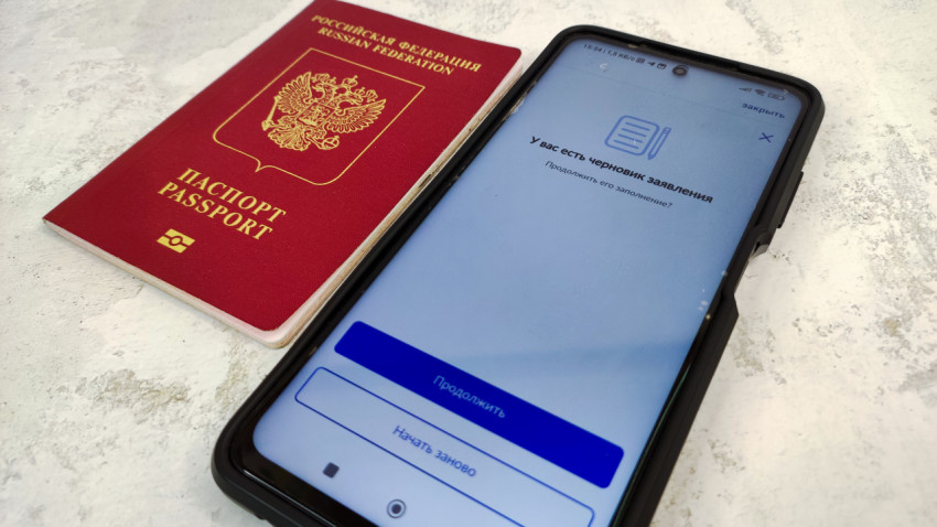 Загранпаспорт РФ и смартфон с уведомлением о черновике заявления