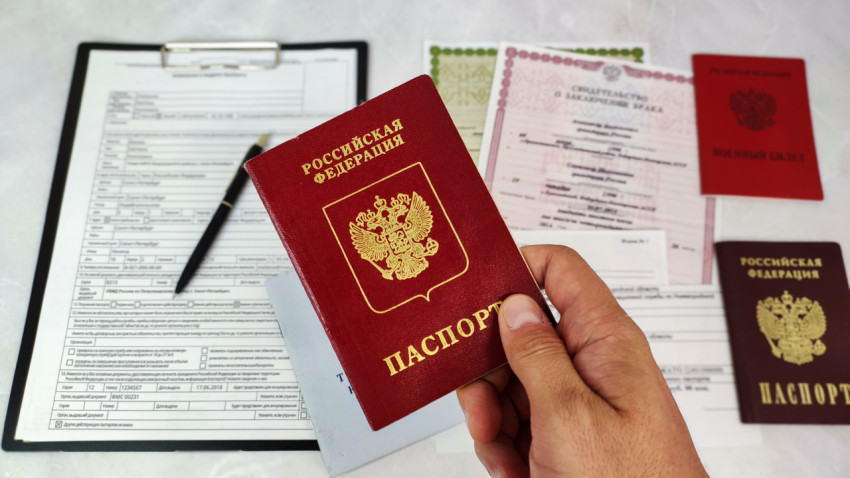 Загранпаспорт РФ в руке и заявление на выдачу паспорта