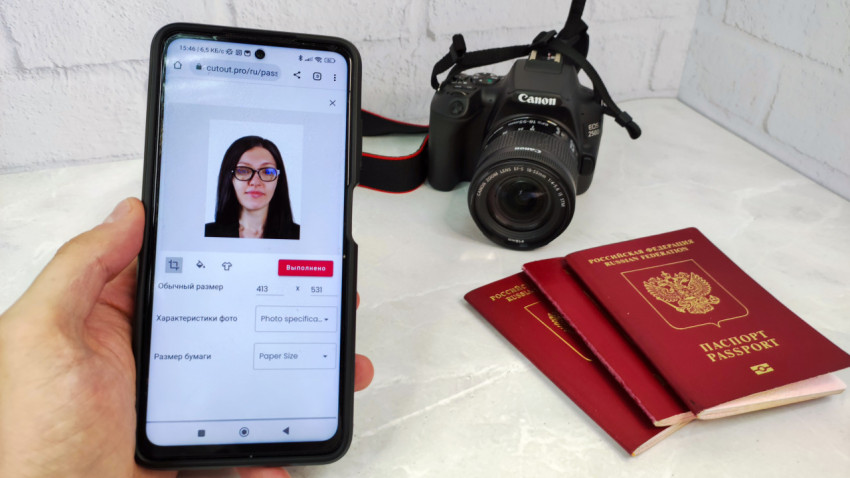 Смартфон с цифровым фото для паспорта и бумажные загранпаспорта рядом