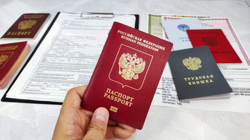Загранпаспорт РФ в руке и комплект личных документов