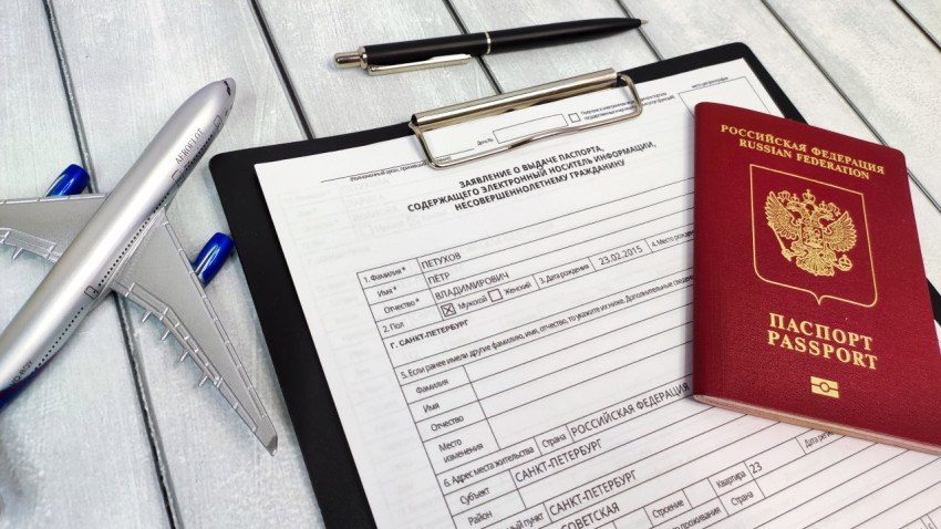 Анкета и загранпаспорт РФ рядом с макетом самолета