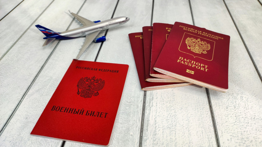 Военный билет и несколько загранпаспортов РФ с моделью самолёта