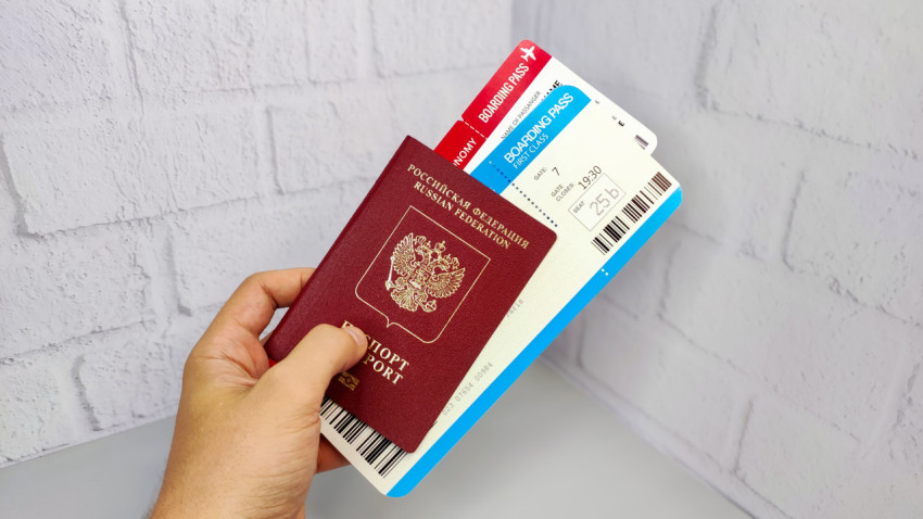Загранпаспорт РФ и посадочные талоны в руке
