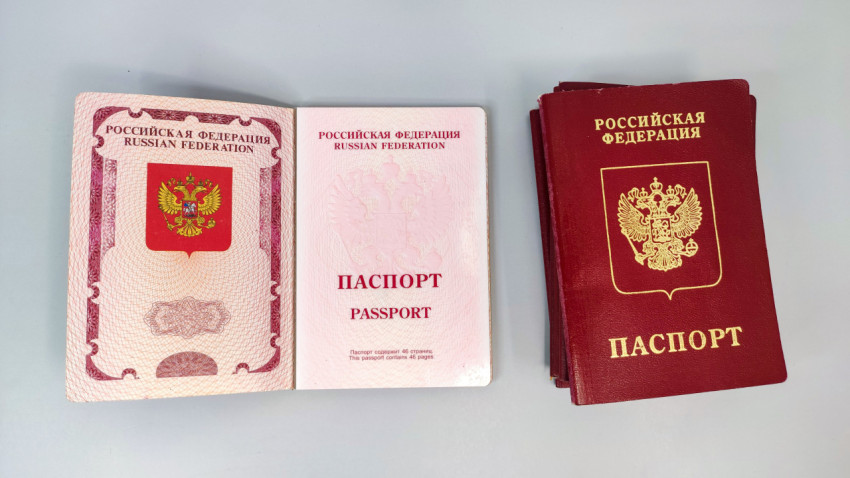 Заграничный паспорт РФ в раскрытом виде и стопка паспортов